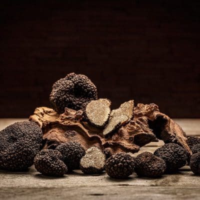 Black truffles mushrooms on rustic wooden table with free text space